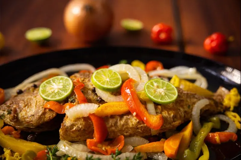 Authentic Jamaican Escovitch Fish at Jerk Harbour, East Legon Accra — fresh whole fish fried until crisp, topped with authentic escovitch vegetables and Scotch…